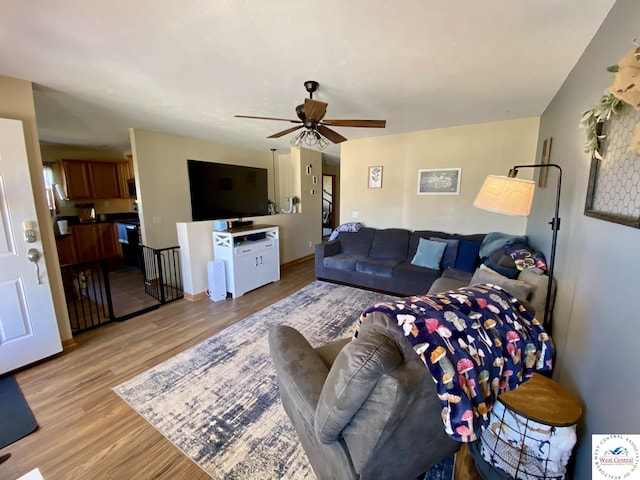 living room featuring ceiling fan and light wood-type flooring