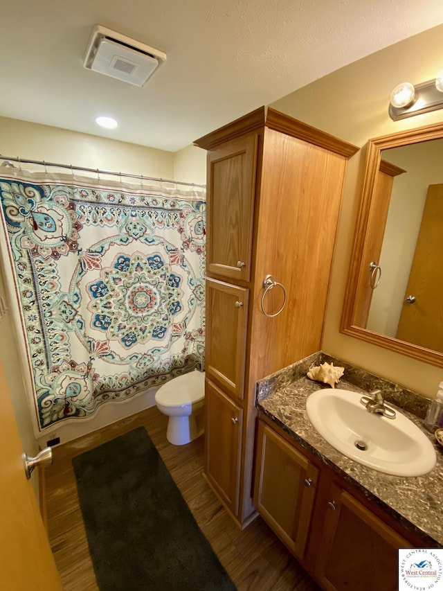 full bathroom with toilet, wood finished floors, visible vents, vanity, and shower / bath combination with curtain