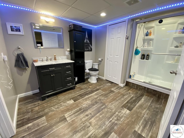 full bath featuring baseboards, visible vents, toilet, wood finished floors, and a shower stall