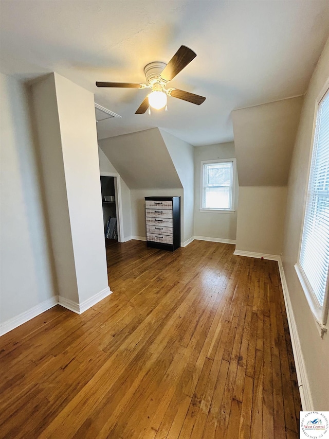 bonus room with lofted ceiling, baseboards, and wood finished floors