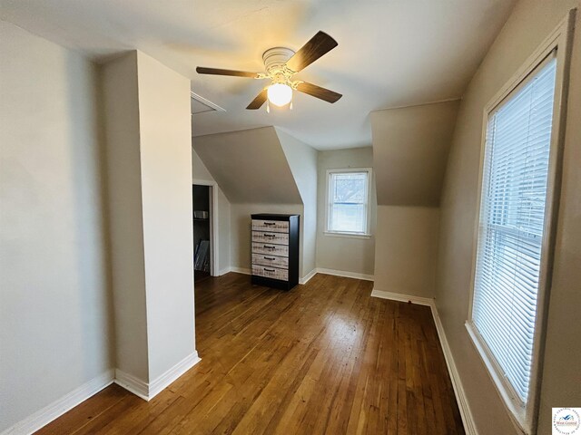 additional living space with ceiling fan, vaulted ceiling, baseboards, and dark wood finished floors