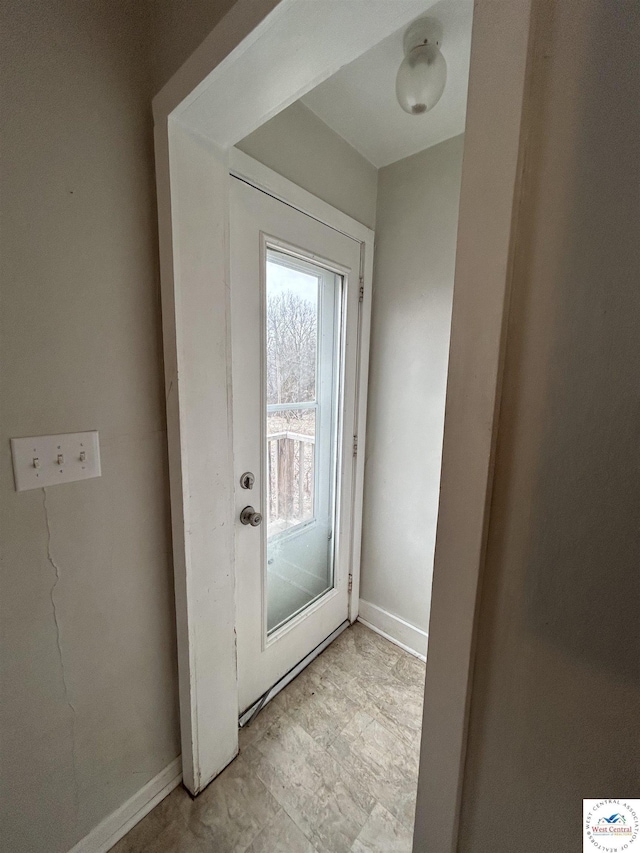 doorway to outside with baseboards