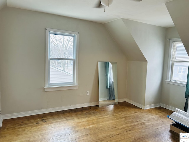 bonus room with vaulted ceiling, ceiling fan, baseboards, and light wood-style floors