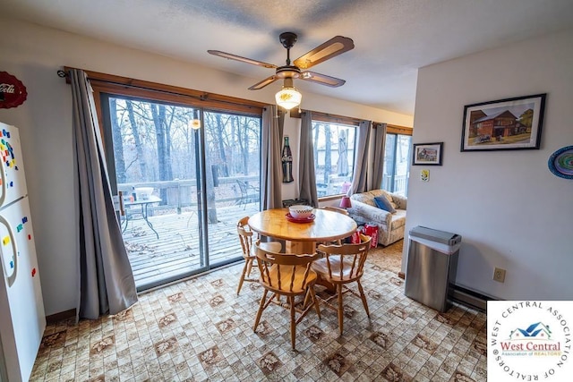 dining space with ceiling fan and baseboards