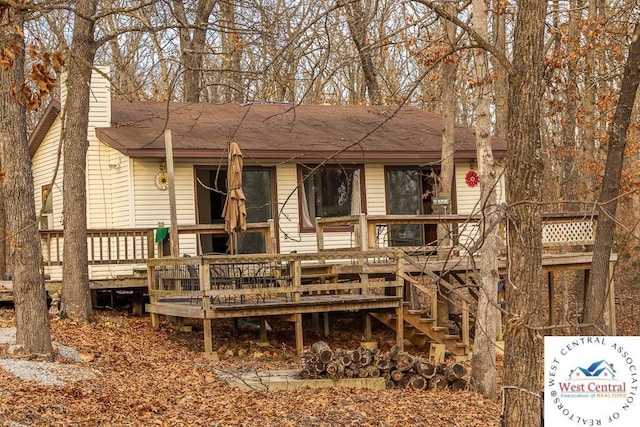 back of house featuring a chimney and a wooden deck