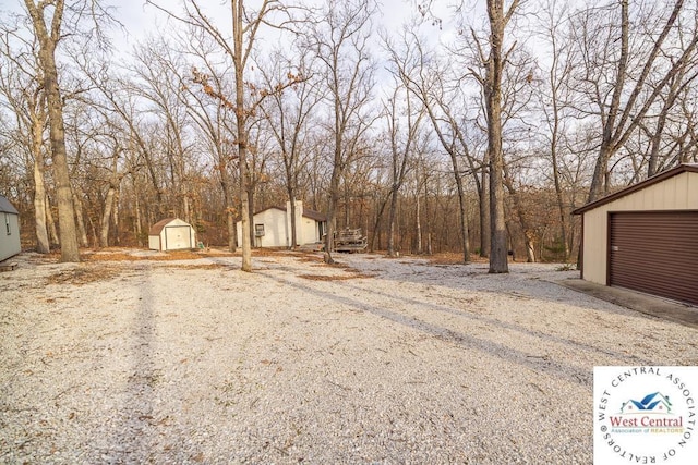 view of yard with a storage shed, an outdoor structure, and a garage