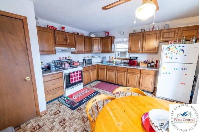 kitchen featuring brown cabinetry, white appliances, light countertops, and under cabinet range hood