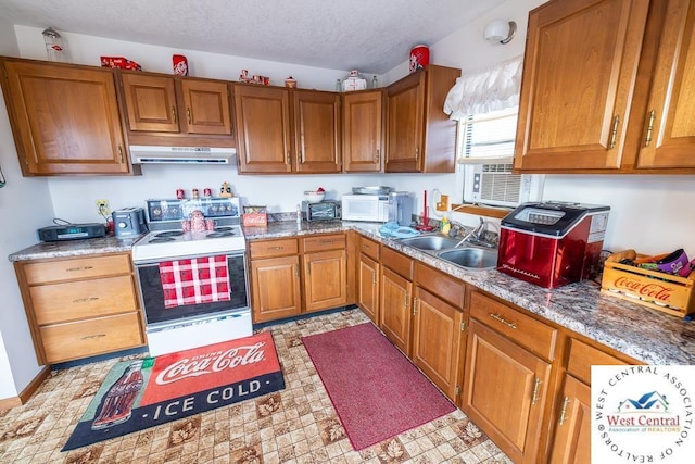 kitchen featuring white appliances, under cabinet range hood, brown cabinetry, and a sink