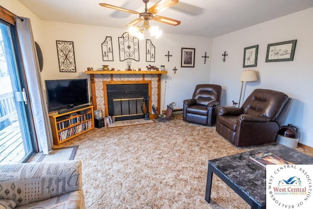 carpeted living area featuring ceiling fan, a fireplace, and baseboards