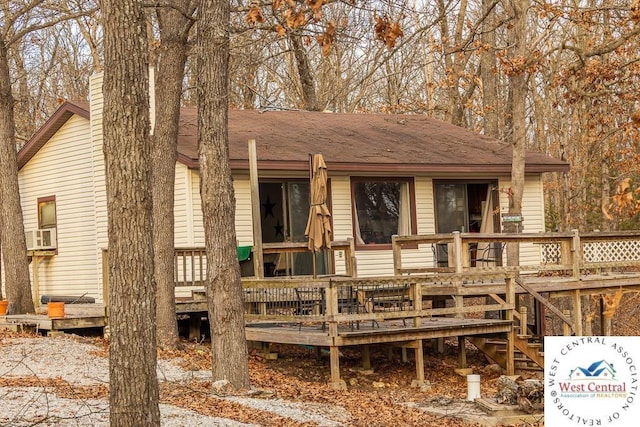 rear view of house with cooling unit and a wooden deck