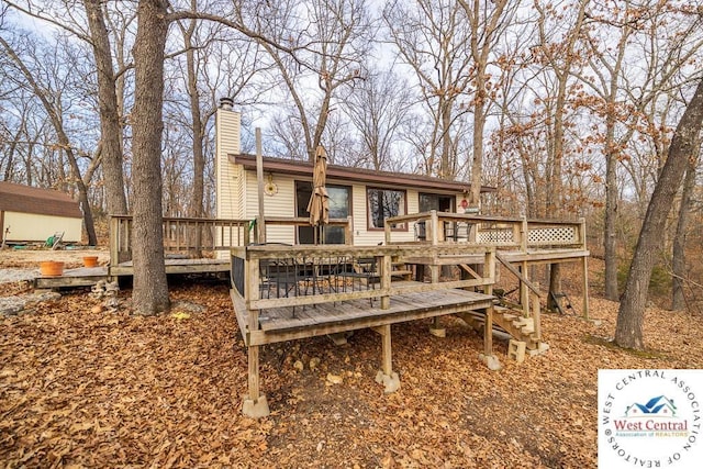 rear view of house with a deck and a chimney