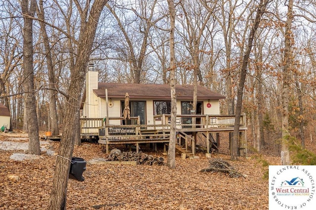 view of front of home with stairs, a chimney, and a deck