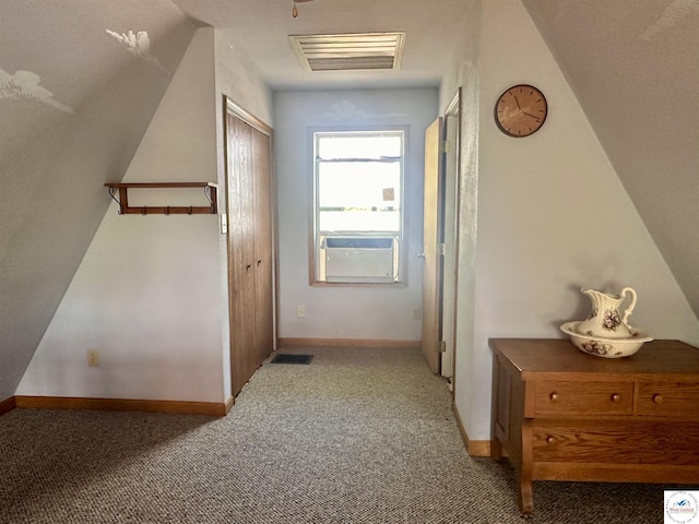 hall with baseboards, visible vents, and carpet floors