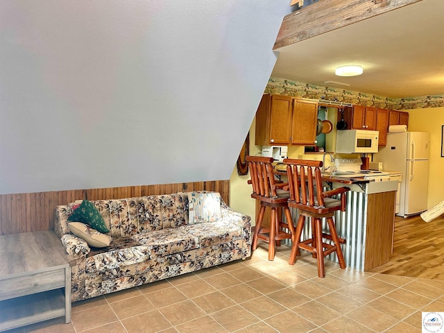 living room with wooden walls and light tile patterned flooring