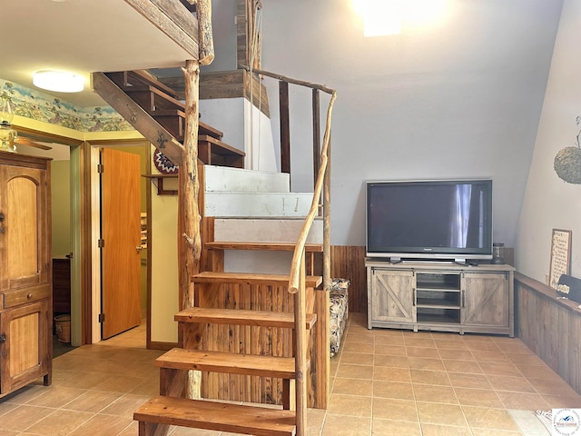 staircase with wainscoting and tile patterned floors