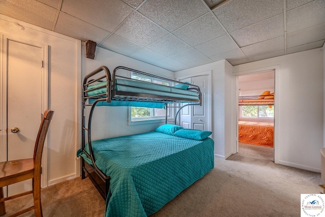 bedroom with baseboards, a paneled ceiling, and carpet flooring