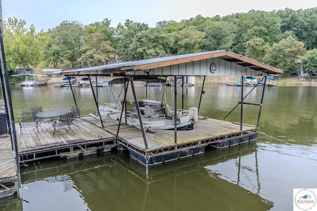 view of dock featuring a forest view and a water view