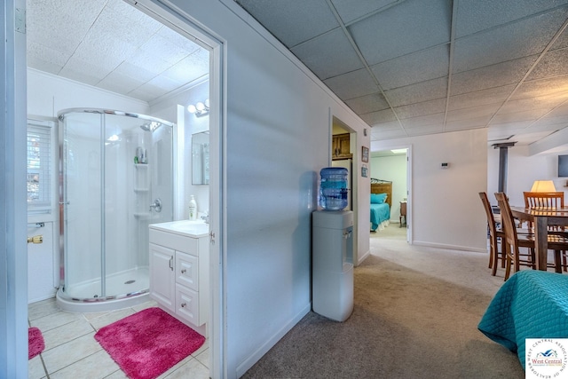 full bath with vanity, a shower stall, a paneled ceiling, and baseboards