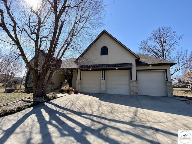 view of front of home featuring driveway, a shingled roof, stone siding, an attached garage, and stucco siding