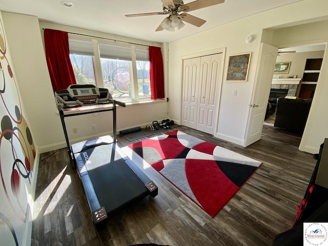 workout room featuring ceiling fan, baseboards, and wood finished floors