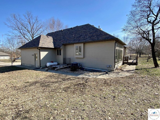 rear view of property with a deck and a shingled roof