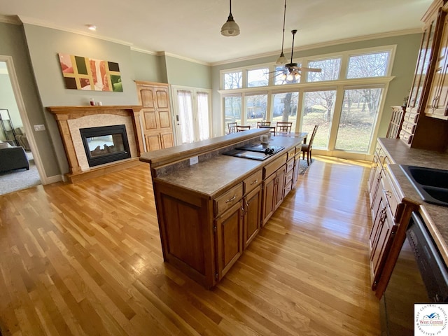 kitchen with crown molding, dishwasher, and a tiled fireplace