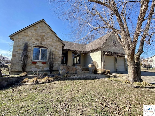 view of front facade featuring a front lawn, stone siding, driveway, and an attached garage