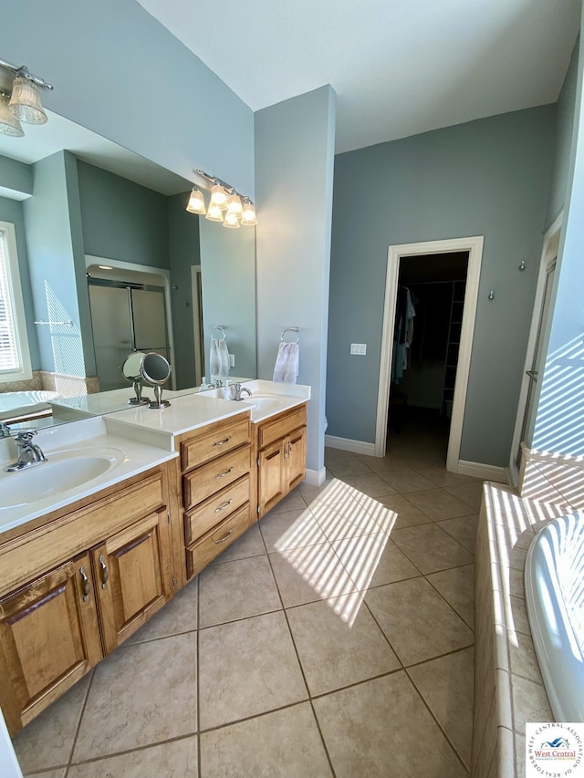 full bath featuring a stall shower, a sink, and tile patterned floors