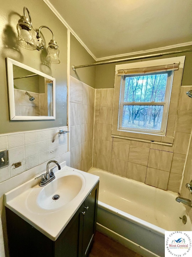 bathroom with ornamental molding, shower / washtub combination, tile walls, and vanity