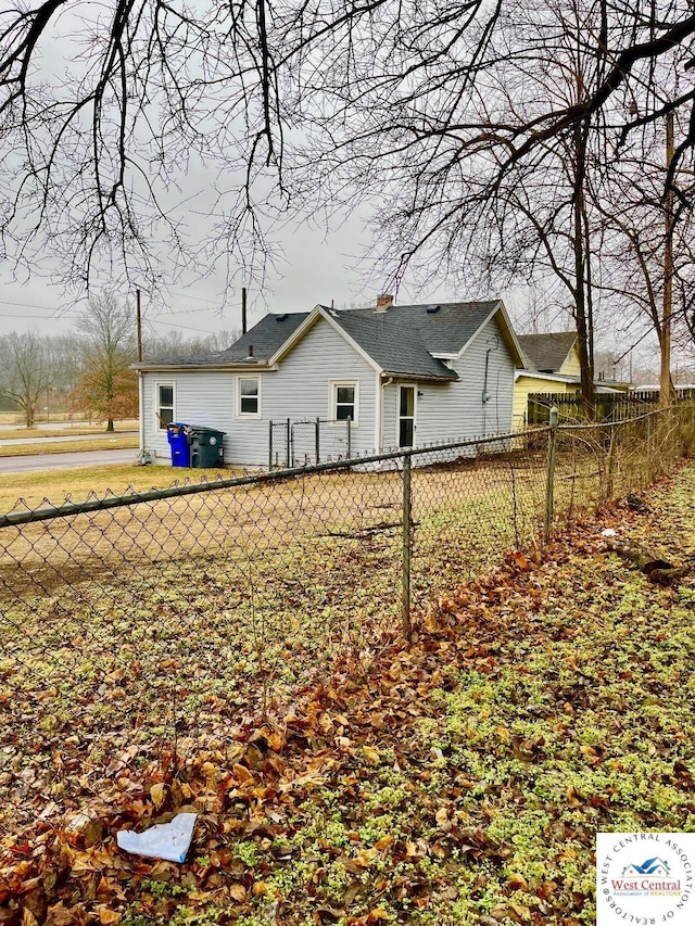 rear view of property featuring fence