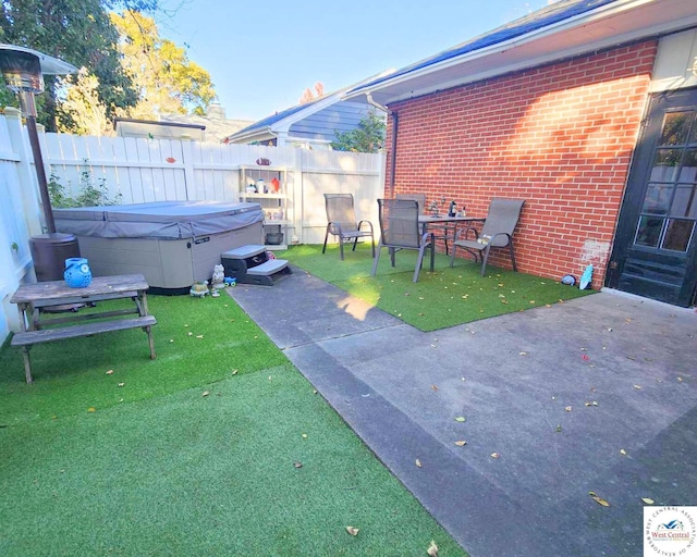 view of patio / terrace featuring fence and a hot tub