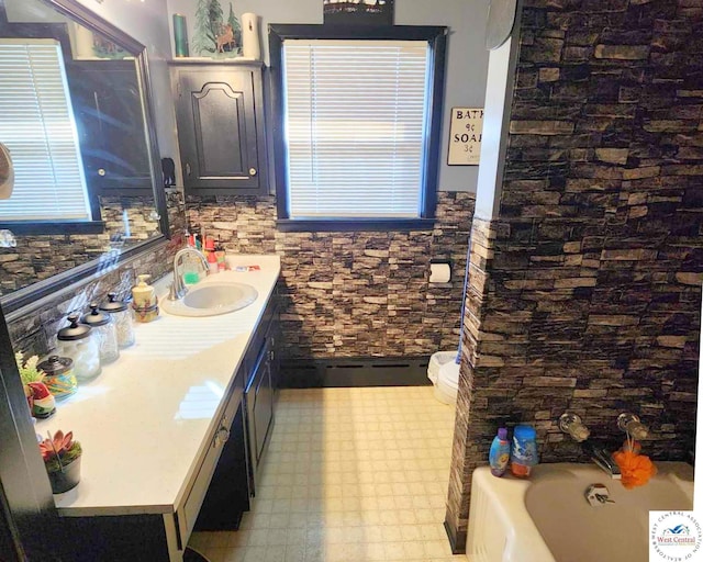 bathroom featuring toilet, vanity, a bath, and tile patterned floors