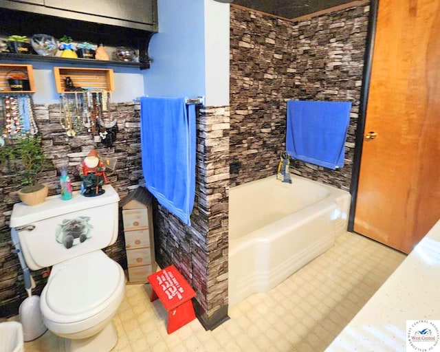 bathroom featuring a garden tub, toilet, and tile patterned floors