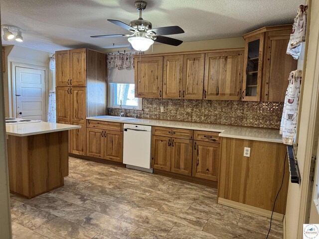 kitchen with glass insert cabinets, brown cabinetry, light countertops, and dishwasher