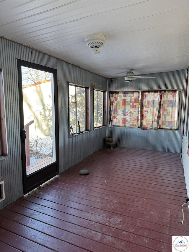 unfurnished sunroom with a ceiling fan