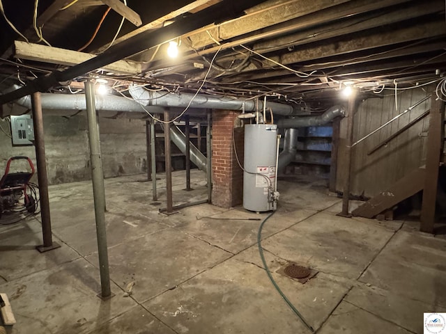 unfinished below grade area featuring electric panel and water heater