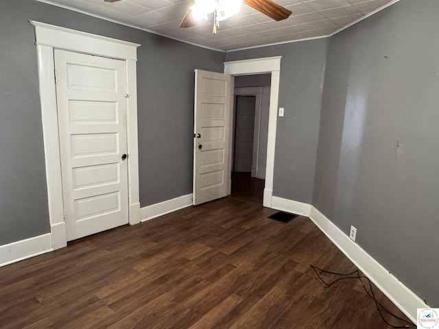 unfurnished bedroom featuring dark wood-style floors, baseboards, and a ceiling fan