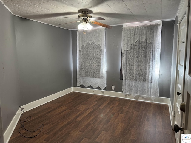 spare room featuring a ceiling fan, baseboards, and wood finished floors