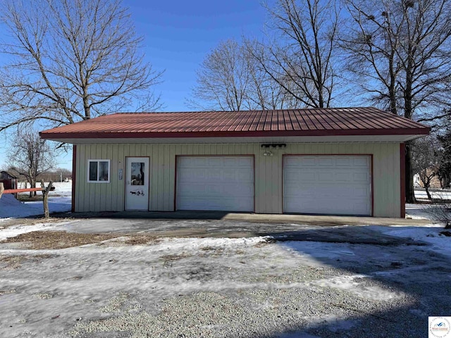 snow covered garage featuring a garage