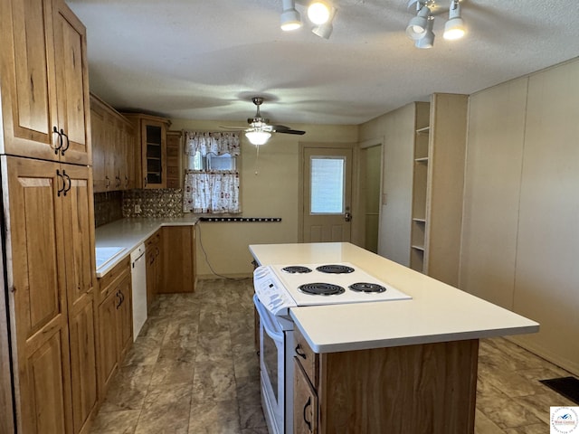 kitchen featuring white appliances, glass insert cabinets, brown cabinets, a center island, and light countertops