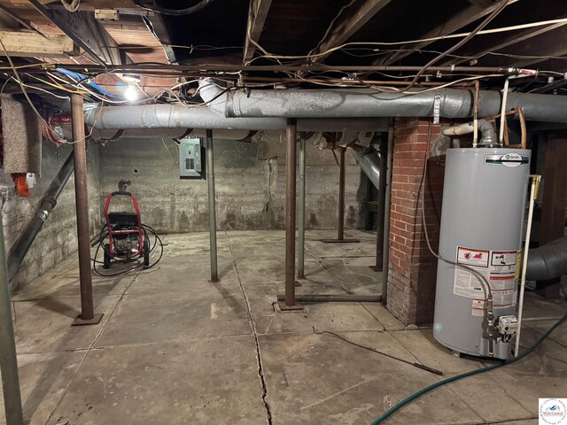 unfinished basement featuring electric panel and gas water heater