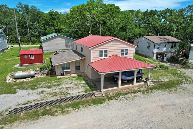 view of front of property featuring an outbuilding, metal roof, and a storage shed