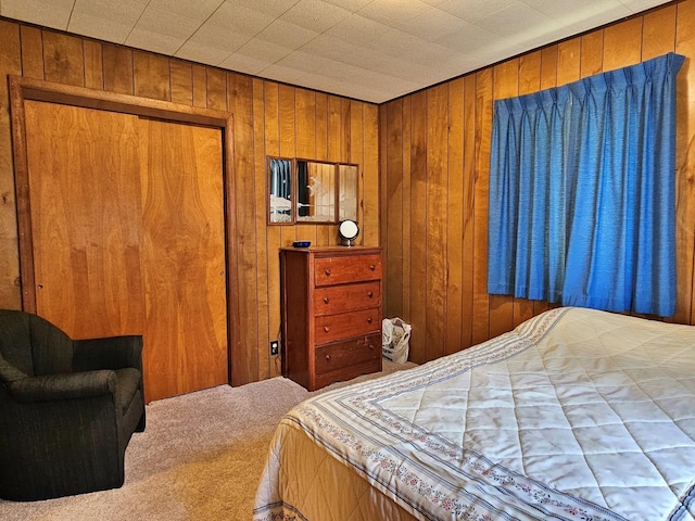 bedroom featuring a closet, wood walls, and carpet flooring