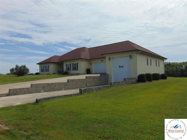 view of front of home with driveway, a front lawn, and a garage