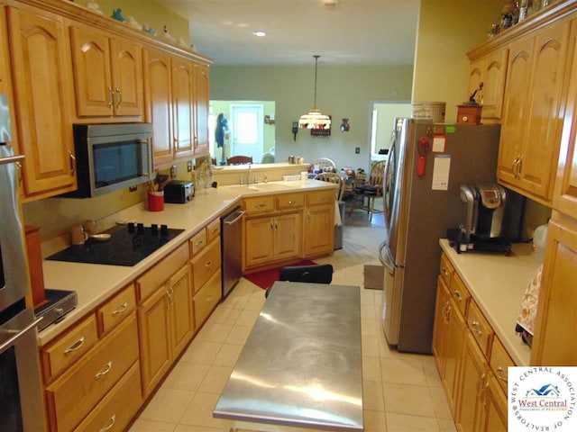 kitchen with decorative light fixtures, light countertops, a peninsula, light tile patterned flooring, and stainless steel appliances