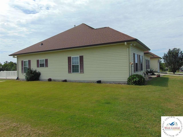 view of property exterior featuring a lawn and roof with shingles