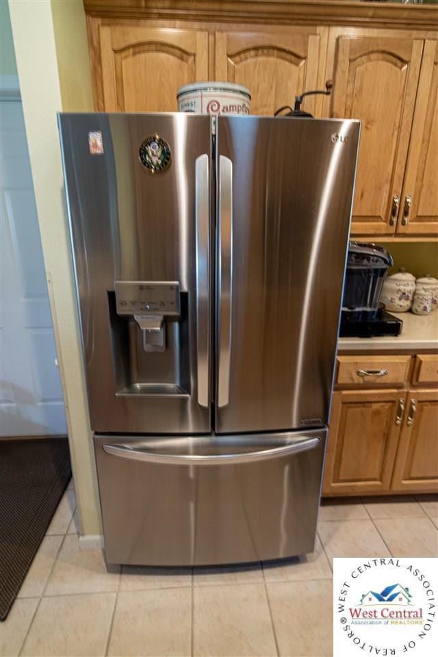 interior details featuring stainless steel fridge, light countertops, and brown cabinets