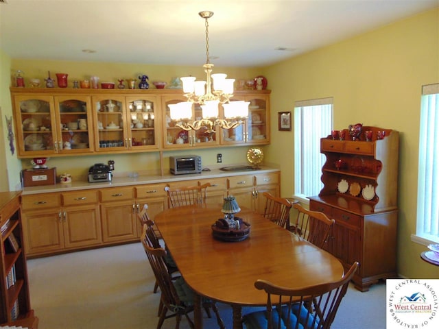 dining area with visible vents, light carpet, a notable chandelier, and a healthy amount of sunlight