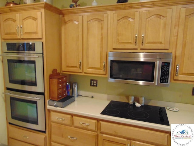 kitchen with light brown cabinets, stainless steel appliances, and light countertops