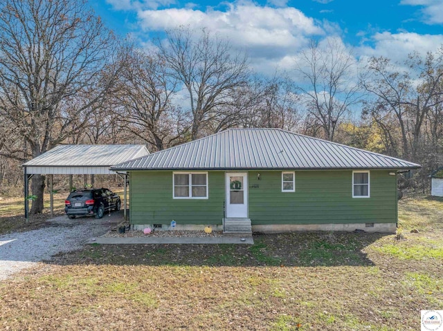 view of front of home with entry steps, a detached carport, metal roof, and crawl space